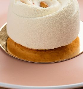 A cake on top of a plate with a roll in the middle.