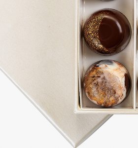 A box of two chocolate covered cookies in it.