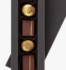 A box of chocolates with gold foil in it.