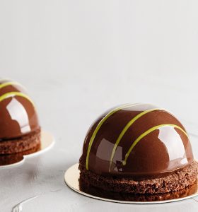 A chocolate cake with yellow and white stripes on top.