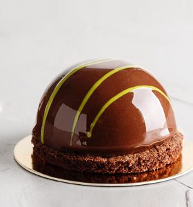 A chocolate cake with yellow and green stripes on top.