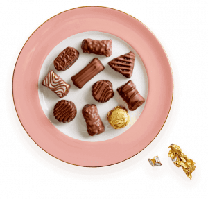 A plate of chocolate covered cookies and candy.