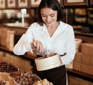 A woman in white shirt holding a box.
