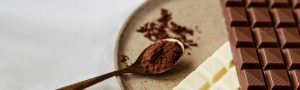 A wooden spoon with chocolate powder on it.