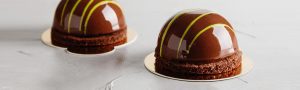 A chocolate cake with yellow and white stripes on top.
