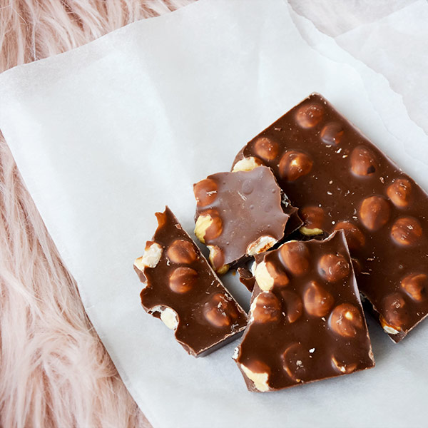 A piece of chocolate with nuts on top.