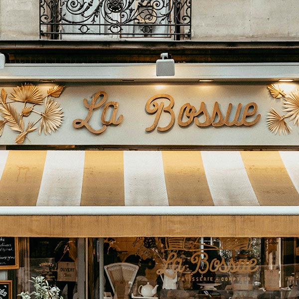 A store front with the name of a restaurant in gold letters.