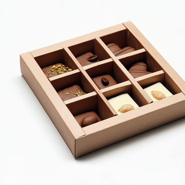 A wooden box with nine different chocolates in it.