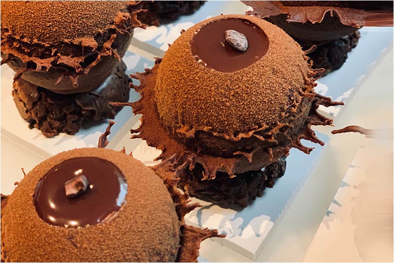 A close up of some chocolate cakes on top of white paper