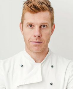 A man in white shirt and red hair.