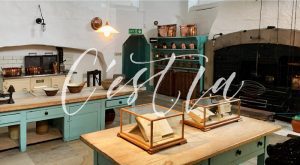 A kitchen with two wooden tables and green cabinets.