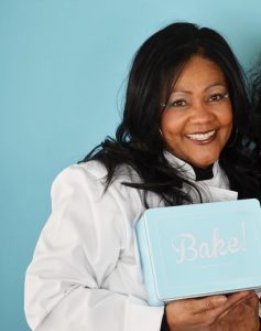 A woman holding a bake box in her hands.