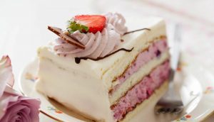 A piece of cake with strawberries on top.