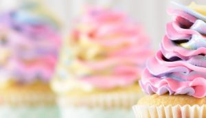 A close up of cupcakes with pink frosting