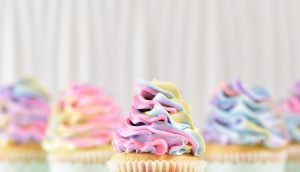 A close up of cupcakes with different colored frosting