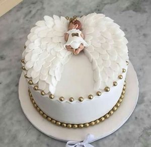 A cake with an angel on top of it.