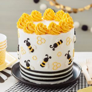 A cake with bees and pretzels on it.