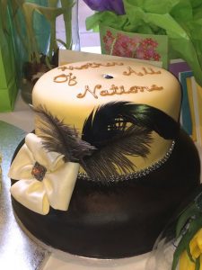 A cake with a bow and feathers on top of it.