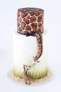 A giraffe and baby giraffe are on the side of this cake.
