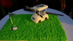A cake shaped like a golf cart on top of grass.