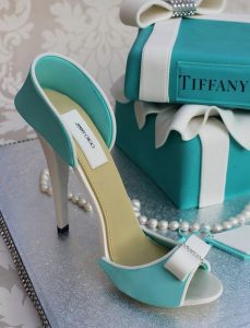 A blue and white shoe next to a box of jewelry.