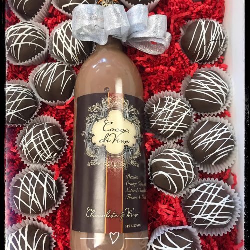 A bottle of wine surrounded by chocolate truffles.