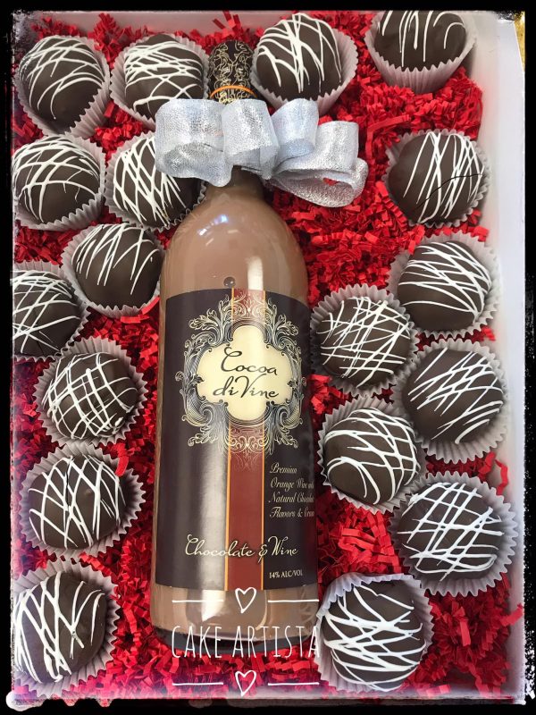 A bottle of wine surrounded by chocolate truffles.