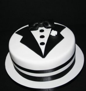 A cake with a tuxedo on top of it.