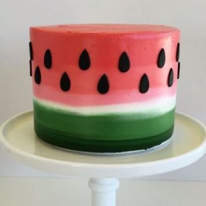 A watermelon cake sitting on top of a white plate.