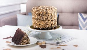 A cake on a plate and two plates with cakes.