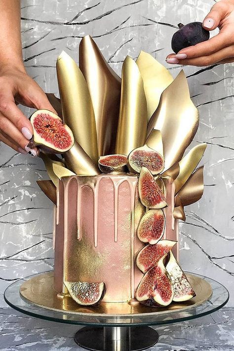 A gold and pink cake with sliced figs on top.