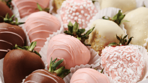 A close up of some pink and white chocolate covered strawberries