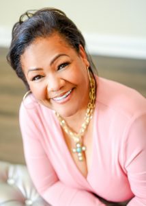 A woman in pink shirt smiling for the camera.