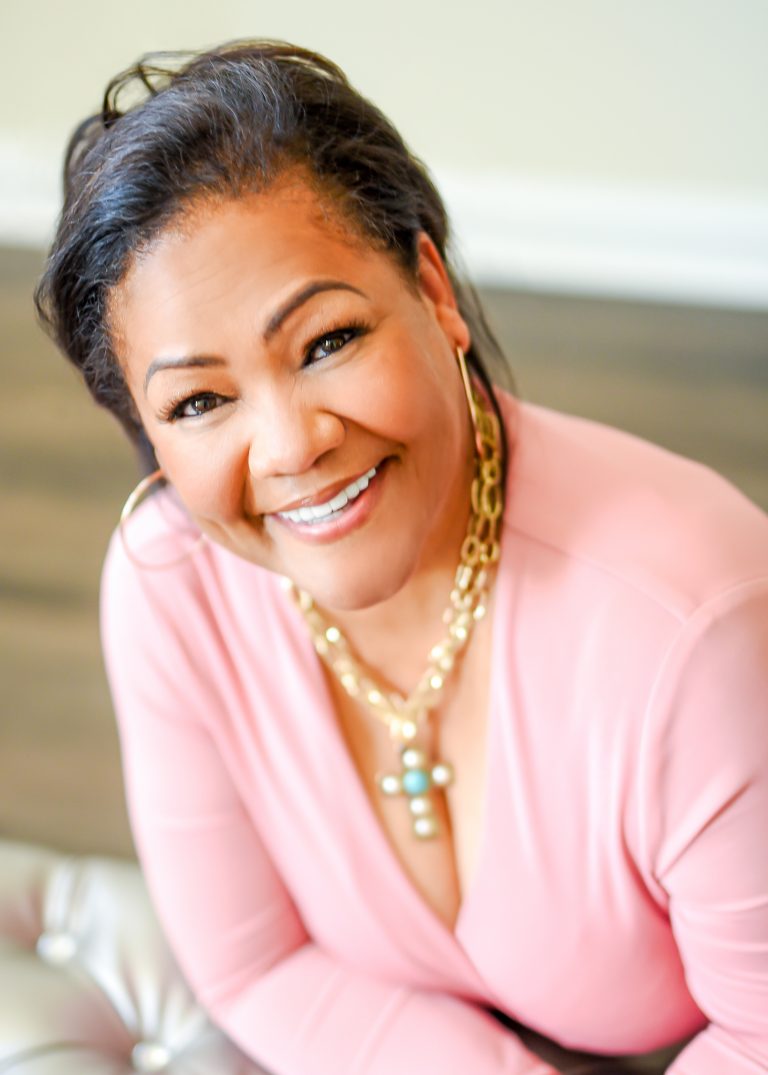 A woman in pink shirt smiling for the camera.