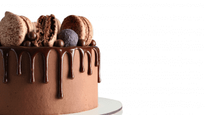 A chocolate cake with macaroons and chocolate sauce.