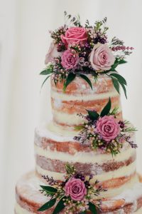 A three layer cake with flowers on top of it.