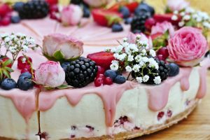 A cake with berries and flowers on top of it.