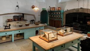 A kitchen with two tables and some jars on the table